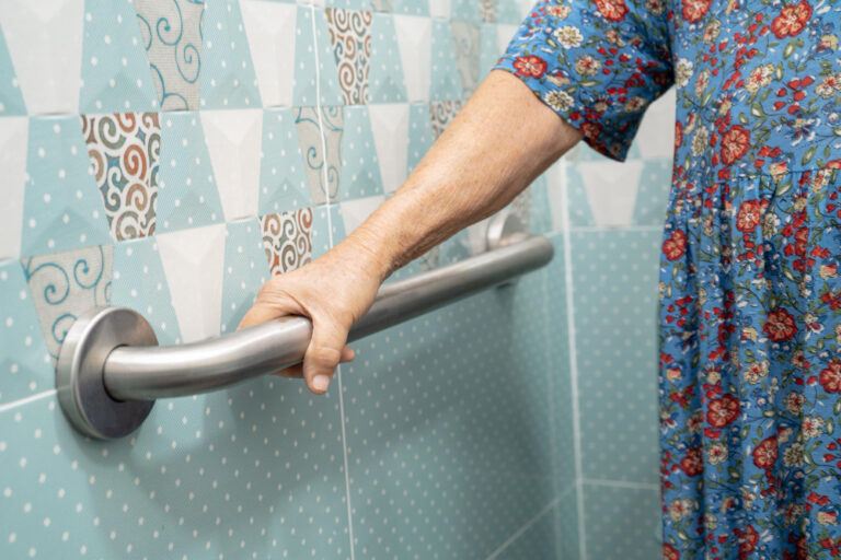 senior using bathroom grab bar for fall prevention and safety
