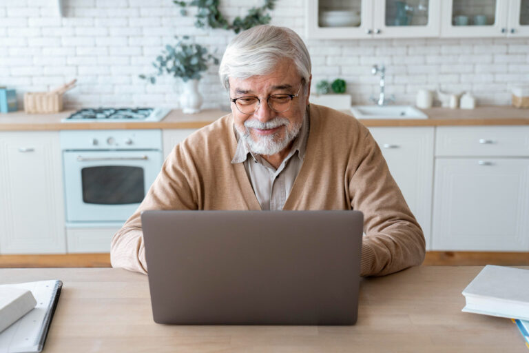 older man using laptop to research long term care and financial planning