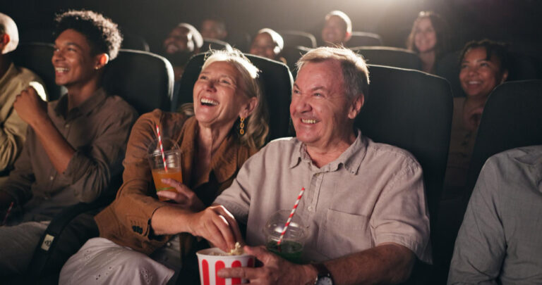 senior couple laughing and enjoying movie night together