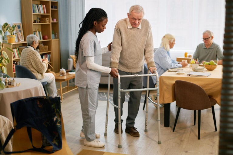 caregiver assisting elderly person using walker