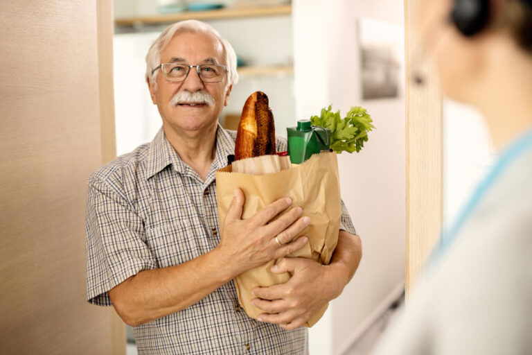 elderly man carrying groceries and living independently
